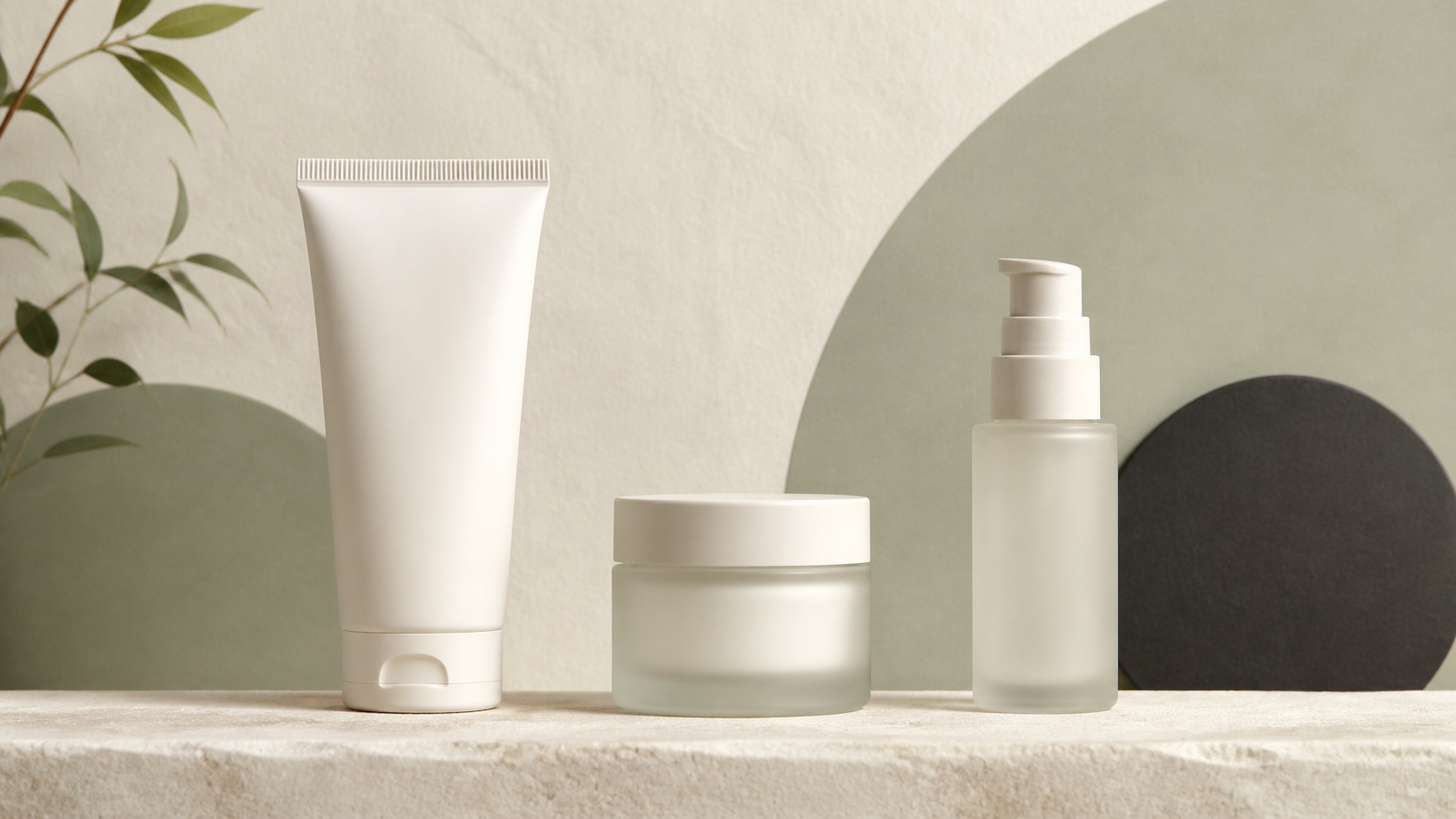 Three unbranded cleanser, moisturizer, and pump containers arranged in a minimal ivory and sage skincare routine